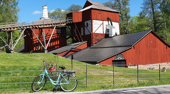 En blå cykel framför den röda hyttan vid Engelsbergs bruk