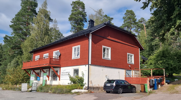 Ängelsbergs brukshandel. Ett rött hus med svart tak. 