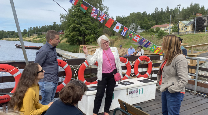 Turistchef Raija Edvinsson står tillsammans med kommunalråd Marino Wallsten, kommunchef Karolina Berglund, landsbygdsminister Anna-Caren Sätherberg med flera på den båtflotte som går ut till Oljeön.