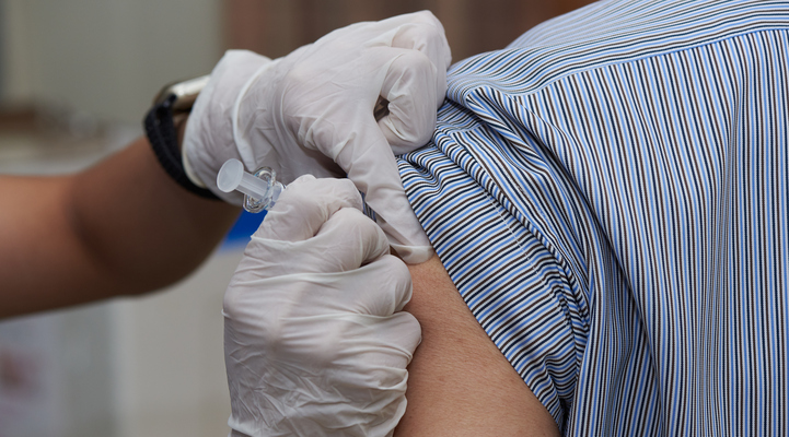 Närbild på en person som får en vaccinationsspruta i armen.