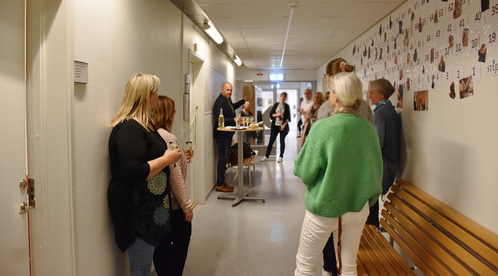 Flera personer står efter väggarna i en korridor i väntan på att få komma in i nya metodrummet.
