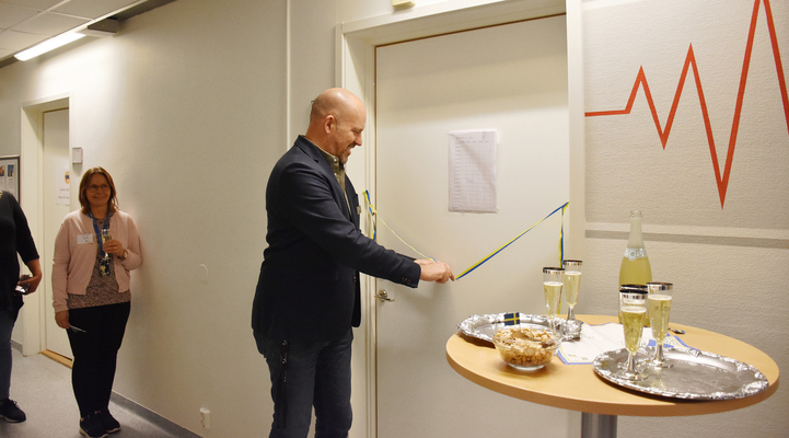 Rektor för Komvux Mattias Pålsson står redo och ska klippa bandet som sitter framför dörren till metodrummet.