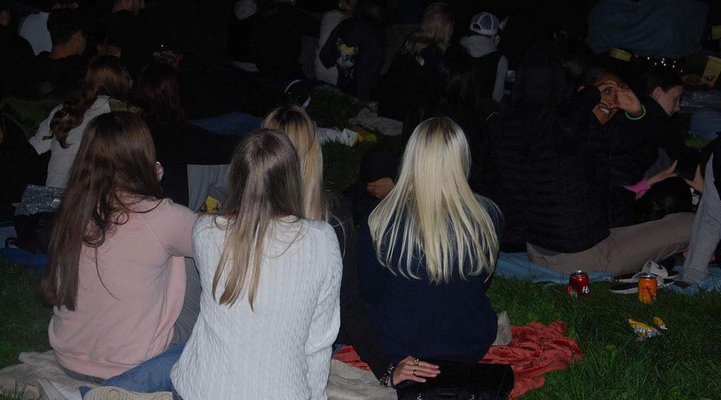 Personer ser på bio utomhus i mörkret