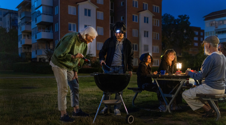Fem personer lagar mat utomhus i mörkret