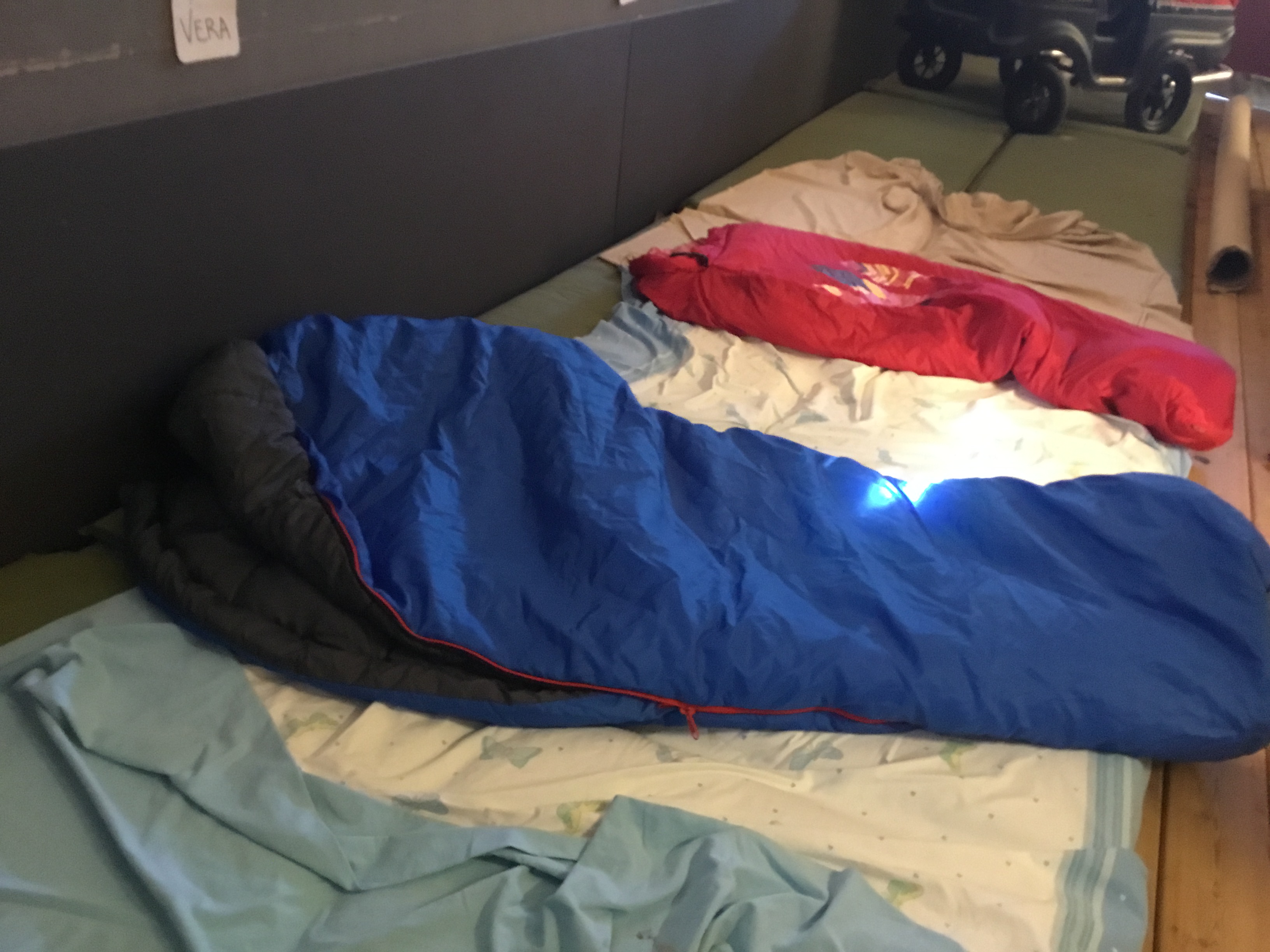 Utesovplats, En röd och en blå sovsäck ligger utlagda på en vit madrass